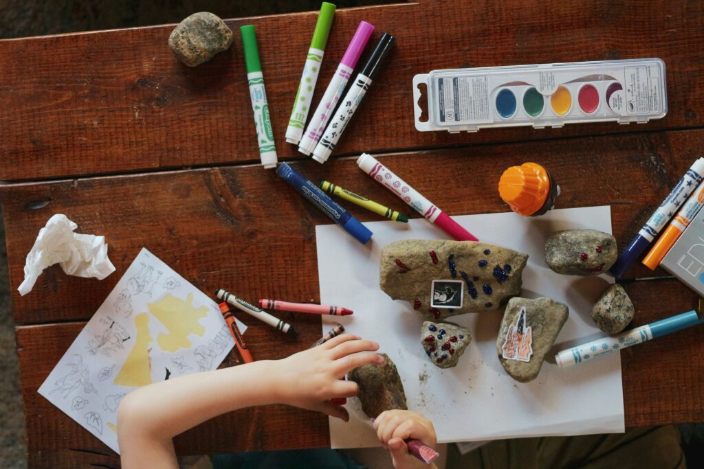 Someone painting rocks with an art kit